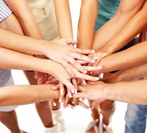 Mani di persone di etnia diversa che si incrociano 