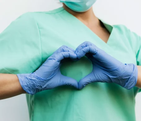 Foto di un dottore che tiene le mani a forma di cuore